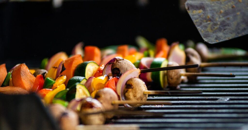 Brochettes de légumes colorés en train de cuire sur un barbecue en plein air